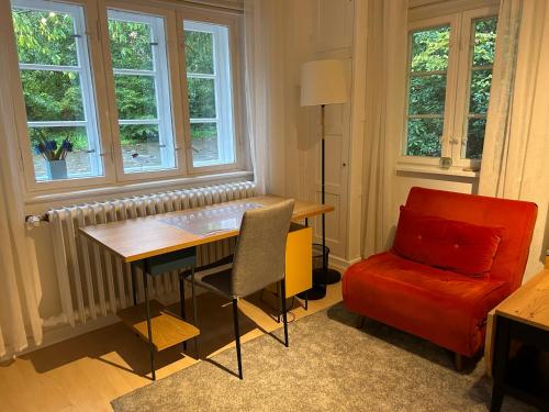 a living room with a table and a chair and windows at Wohlfühlort in Felde bei Kiel in Felde