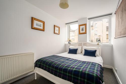 a bedroom with a bed with a plaid blanket at The Riverside Hideaway by Calton Living in Edinburgh