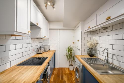 a kitchen with blue cabinets and a sink at The Riverside Hideaway by Calton Living in Edinburgh