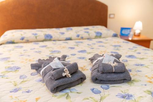 uma cama com toalhas em cima em [NEL CUORE DELLA CITTADINA TERMALE] MAISON M&V em Montecatini Terme