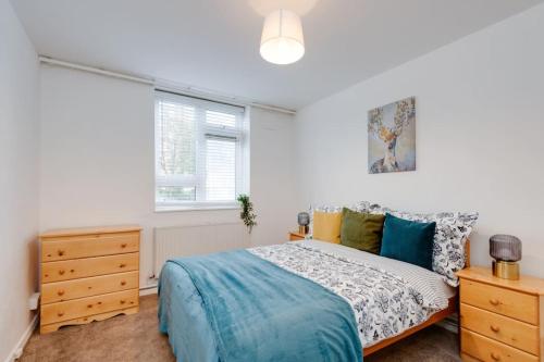 a bedroom with a bed and a window at Lovely 3bed split level flat with outside space in London