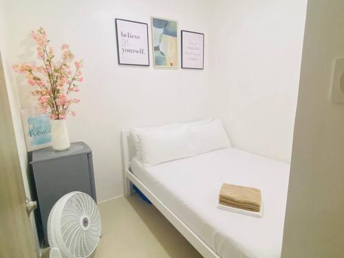 1 dormitorio pequeño con 1 cama y ventilador en Lovely Fame@5SYu, en Manila