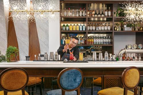 a man sitting at a bar with a drink at Gloud Hotel in Hanoi