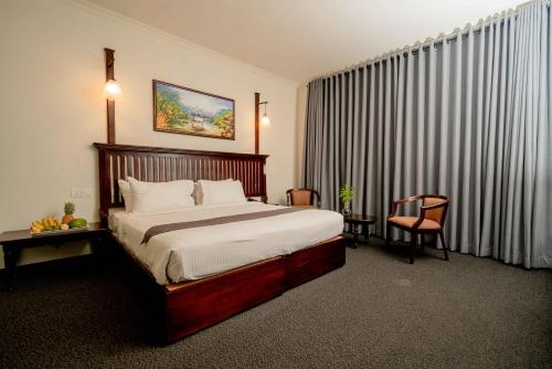 a hotel room with a bed and a window with curtains at Hotel Nippon Colombo in Colombo