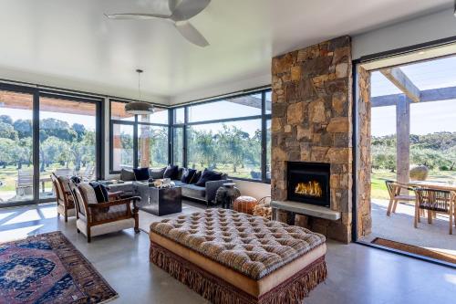 a living room with a large stone fireplace at Ginahgulla Olive Estate I Private Properties in Margaret River Town