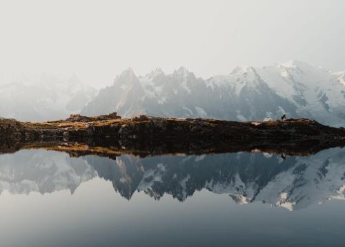 a reflection of a mountain in the water at Big Sky Hotel & Spa in Chamonix-Mont-Blanc
