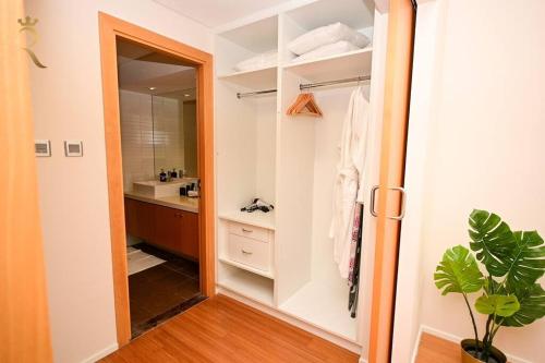 a bathroom with a closet with a sink and a mirror at 1BR Apartment Retreat for Your Getaway In Al Muneera in Abu Dhabi