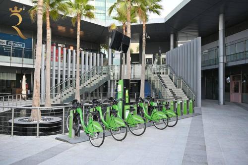 a row of green bikes parked in front of a building at 1BR Apartment Retreat for Your Getaway In Al Muneera in Abu Dhabi