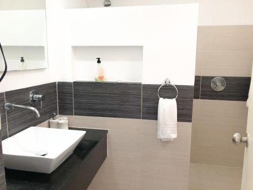 ein Badezimmer mit einem weißen Waschbecken und einem Spiegel in der Unterkunft Saman - Paradise With A View - Vista Mare in Santa Bárbara de Samaná