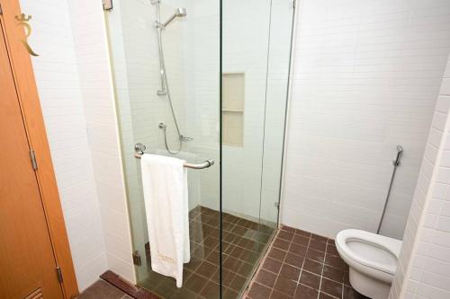 a bathroom with a glass shower stall with a toilet at 1BR Apartment Retreat for Your Getaway In Al Muneera in Abu Dhabi