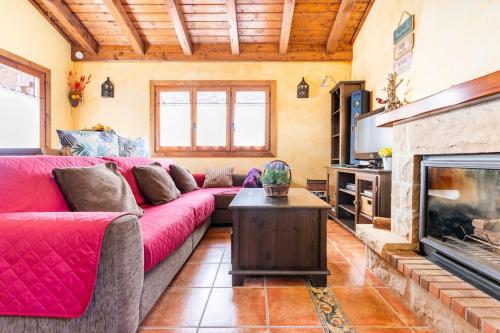 a living room with a red couch and a fireplace at La Voz del Silencio in Neril