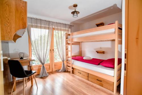 a bedroom with a bunk bed with a desk and a chair at Budimberg Kuća za odmor s bazenom in Ludbreg