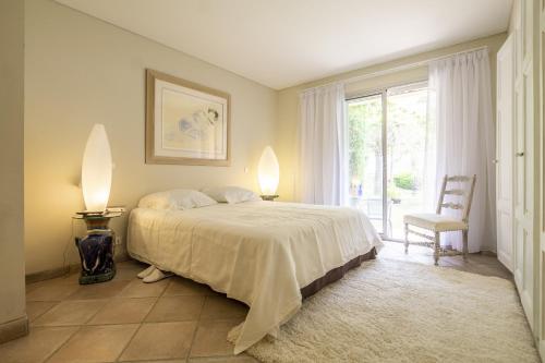 1 dormitorio con 1 cama, 1 silla y 1 ventana en Villa Ambre, en Digne-les-Bains