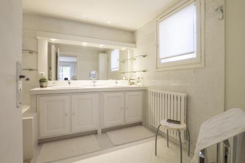 a white bathroom with a sink and a mirror at Villa Ambre in Digne-les-Bains