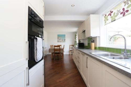 a kitchen with white cabinets and a black refrigerator at BOURNECOAST: Stones throw from the Quay - HB5666 in Bournemouth