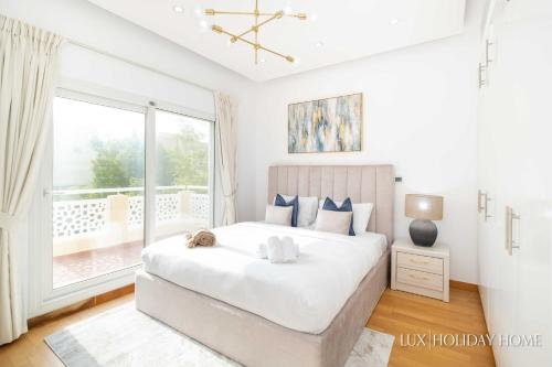 a bedroom with a large bed and a large window at LUX The Meadows 5 Bed Villa in Dubai
