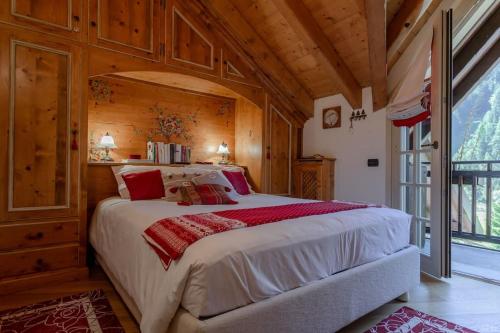 um quarto com uma cama grande num quarto com paredes de madeira em Casa di Beatrice em Ponte di Legno