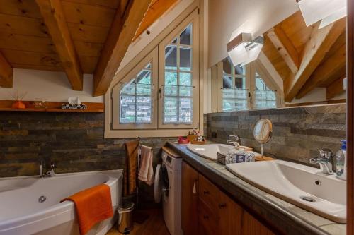 un bagno con due lavandini e una vasca di Casa di Beatrice a Ponte di Legno