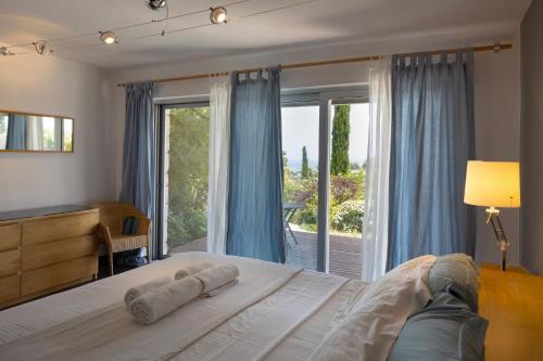 a bedroom with a bed and a large window at Ionian Dream Villas in Lefkada Town