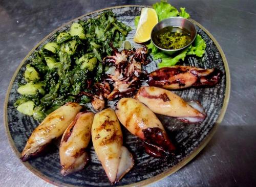 a plate of food with seafood and vegetables on a table at Apartmani Drijen in Ravno