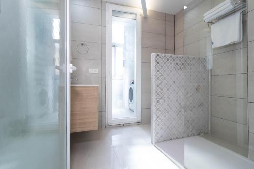 ein Bad mit einer Dusche und einer Glastür in der Unterkunft Piso reformado en el centro histórico PARKING GRATIS Check-in 24 h in Saragossa
