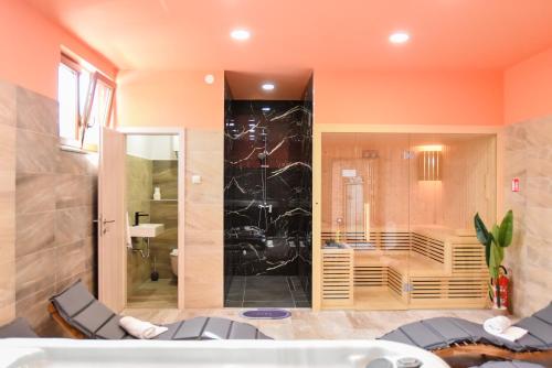 a bathroom with a tub and a glass shower at Bazen & Spa Oasis Budimberg in Ludbreg
