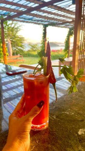 a hand holding a drink with a plant in it at Lobster Bay Lombok in Awang