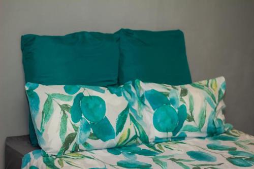 a bed with a green headboard and pillows on it at Arecavilla guesthouse in Newcastle