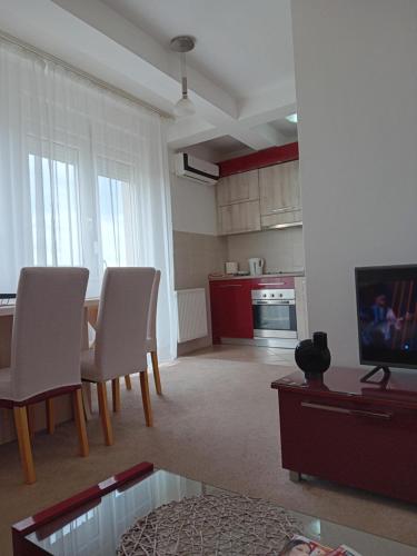 ein Wohnzimmer mit einem Tisch und Stühlen sowie einem TV in der Unterkunft WING 3 apartman ,,BC ,, in Jagodina