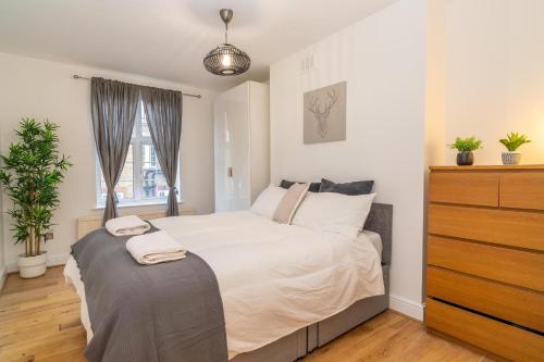 a bedroom with a bed with a dresser and a window at Location! 2 bed/2bath - Pro Host in London
