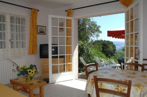 d'une salle à manger avec une table et une porte coulissante en verre. dans l'établissement Appartement T 2 vue mer, à Cavalaire-sur-Mer