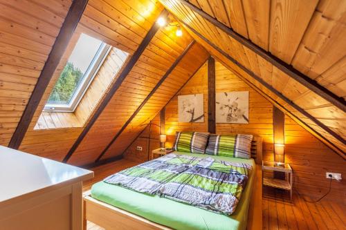 a bedroom with a bed in a wooden attic at Ferienwohnungen Zum Hasenbahnhof in Kirchhundem