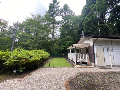 a small house with a yard with a porch at 森の中のぽつんとワンワン別荘 in Nikko