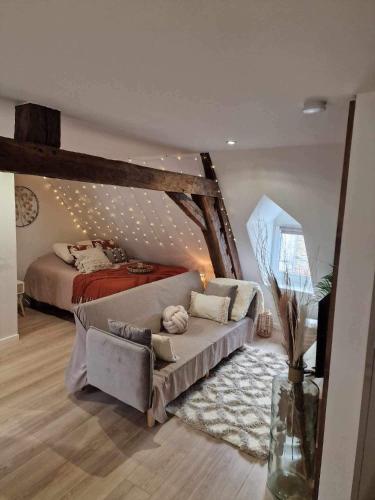 ein Wohnzimmer mit einem Sofa und einem Bett in der Unterkunft Appartement cocooning in Solre-le-Château