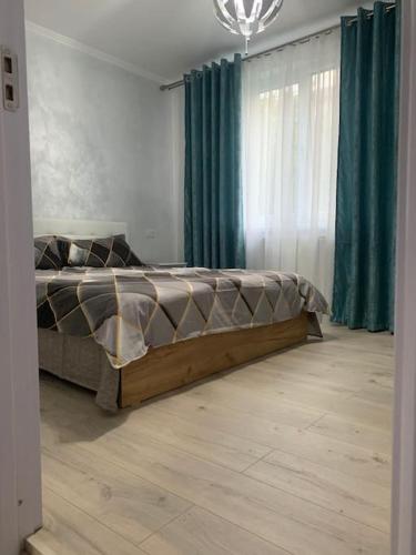 een slaapkamer met een bed in een kamer met groene gordijnen bij Apartament in complex rezidențial in Râmnicu Vâlcea
