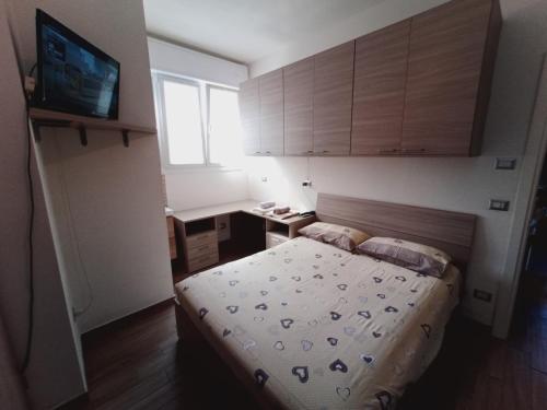 a small bedroom with a bed and a television at Alcova Nicolò Biondo in Modena