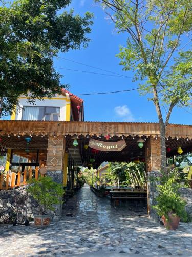 a stone building with awning and a tree at Ninh Binh Royal Homestay in Ninh Binh