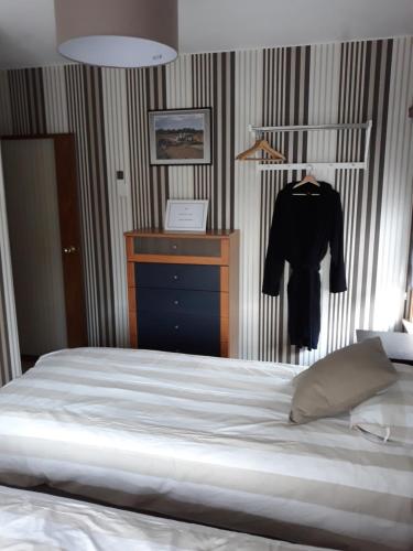 a bedroom with a bed and a black shirt on a rack at Wenceslas Cobergher IV in Bertem