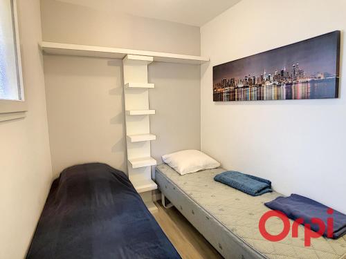 - une petite chambre avec un lit et une étagère dans l'établissement Appartement de standing trois chambres, centre ville, à Sainte-Maxime
