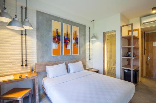 a bedroom with a large white bed in a room at FRii Bali Echo Beach in Canggu