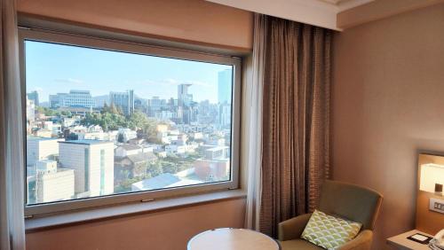 a window in a hotel room with a view of a city at Novotel Ambassador Seoul Gangnam in Seoul
