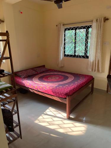 a bed in a room with a window at NO NAME GUESTHOUSE in Arambol