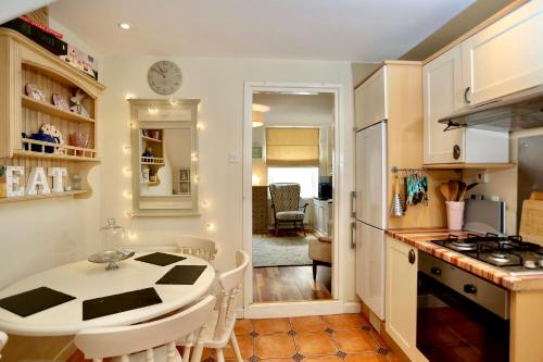 a kitchen and dining room with a table and a counter top at Caboodles Cottage in Crickhowell