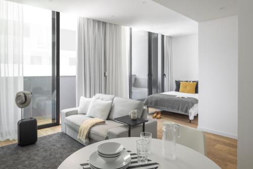a white living room with a couch and a bed at Aveiro Urban Twins in Aveiro