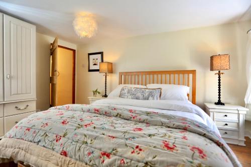 a bedroom with a large bed and two lamps at Caboodles Cottage in Crickhowell