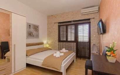 1 dormitorio con 1 cama y TV en Apartments Maky & Dino, en Vodice