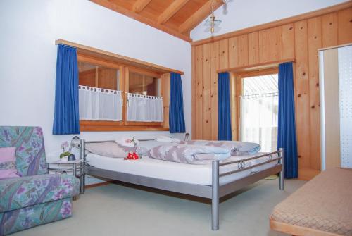 ザムナウンにあるHaus zur Postのベッドルーム1室(青いカーテンとソファ付きのベッド1台付)