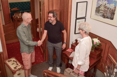 two men and a woman standing in a room shaking hands at Hotel Barbara in Freiburg im Breisgau