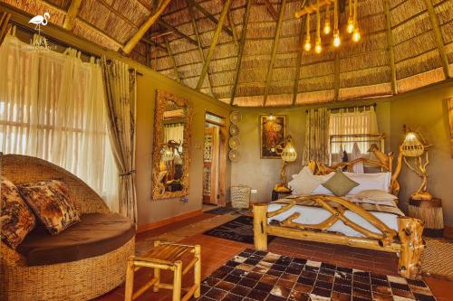 a bedroom with a bed and a couch in a room at Lake Munyanyange Caves Lodge in Kasese