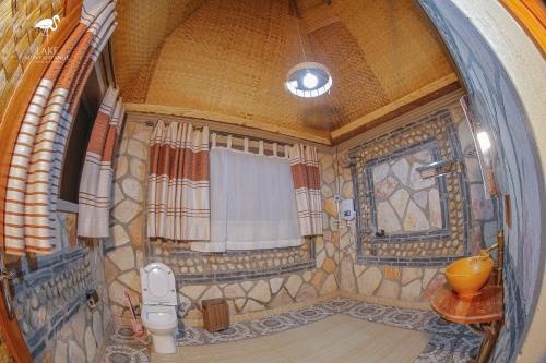 La salle de bains est pourvue d'une douche, d'une fenêtre et de toilettes. dans l'établissement Lake Munyanyange Caves Lodge, à Kasese